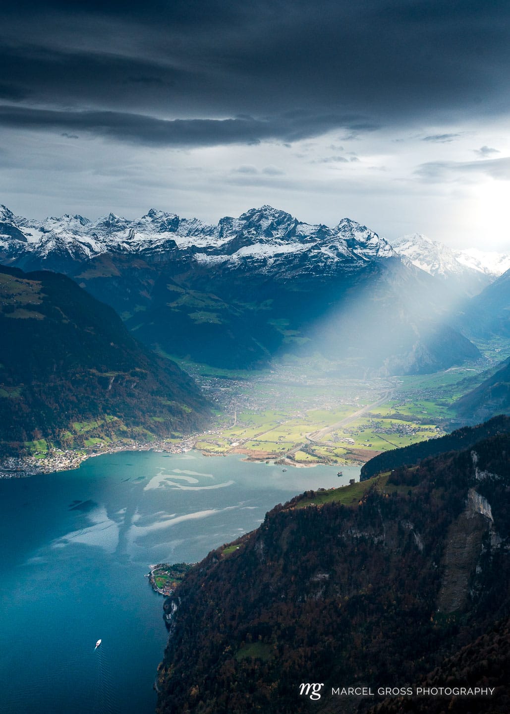sun rays shining into the Reuss level with Altdorf, Flüelen, Schattdorf, Gross Windgällen, Bristen and Urnersee. Taken by Marcel Gross Photography