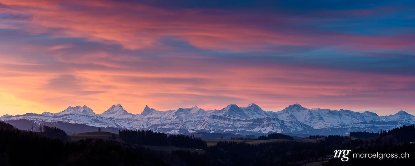 . colorful winter sunrise in Emmental with the Bernese Alps in the distance. Marcel Gross Photography
