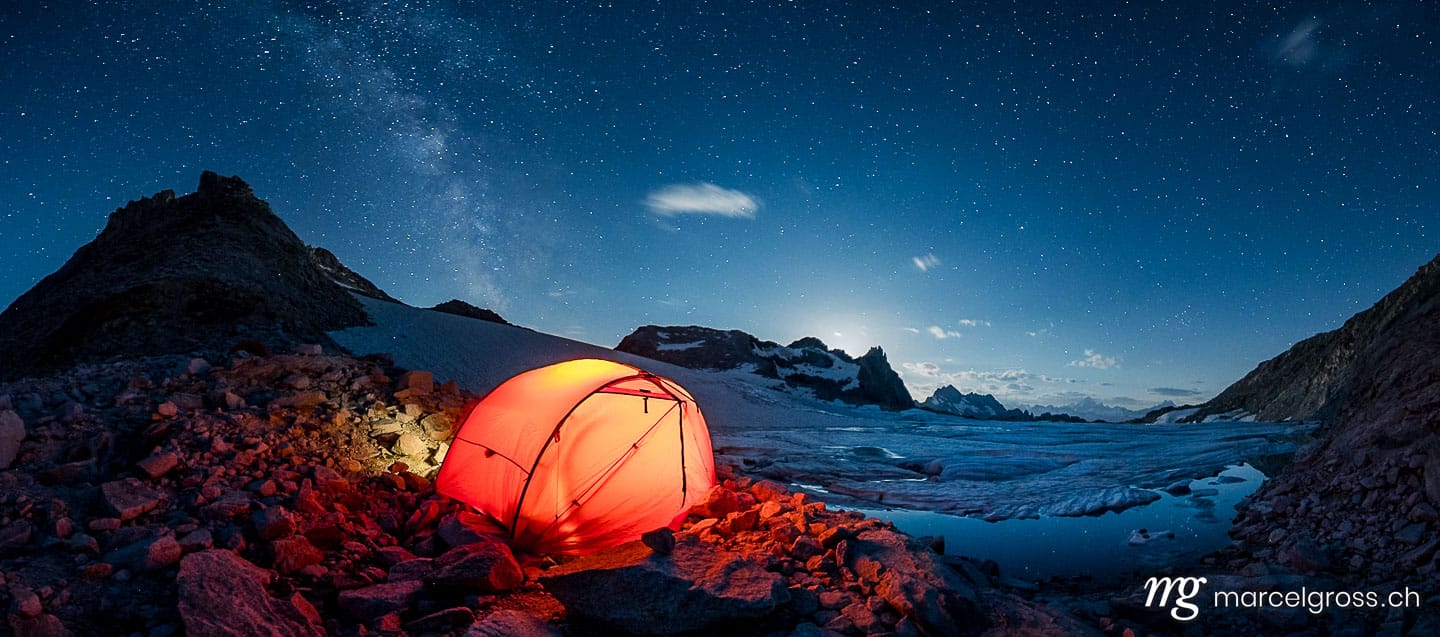 Panoramabilder Schweiz. red tent camping at a glacier lake in the swiss alps. Marcel Gross Photography