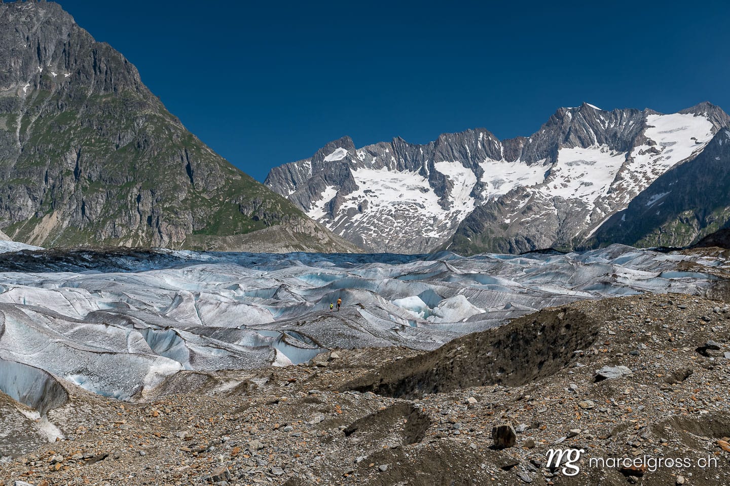 . a man and his son on the ice of the mighty Aletschgletscher. Marcel Gross Photography