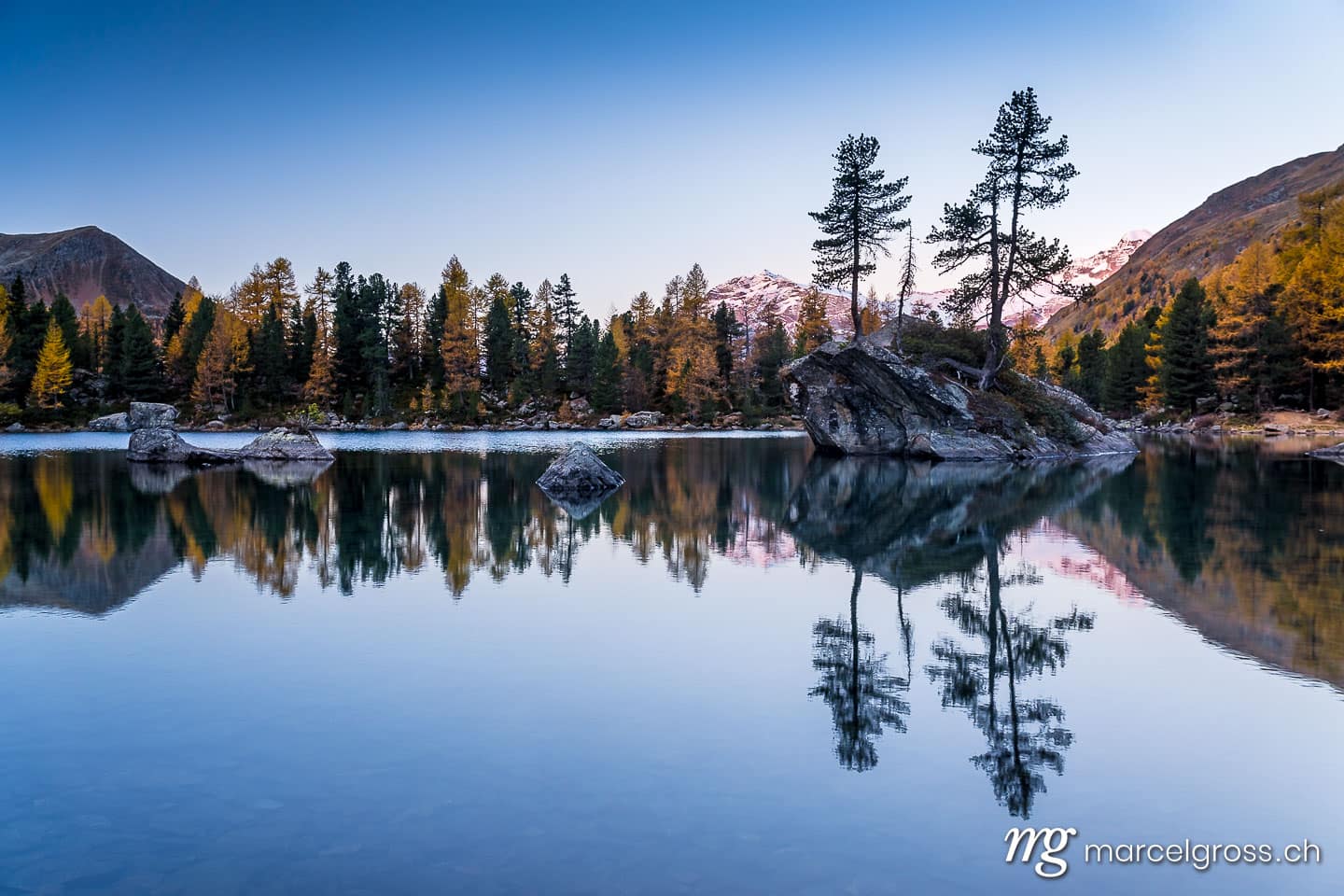 . sunrise at an alpine lake with refleciton in autumn. Marcel Gross Photography