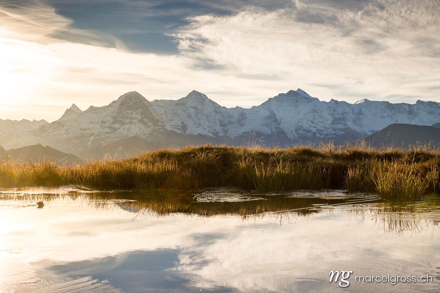 . sunrise over a pond in the Bernese Alps with Eiger Mönch and Jungfrau. Marcel Gross Photography