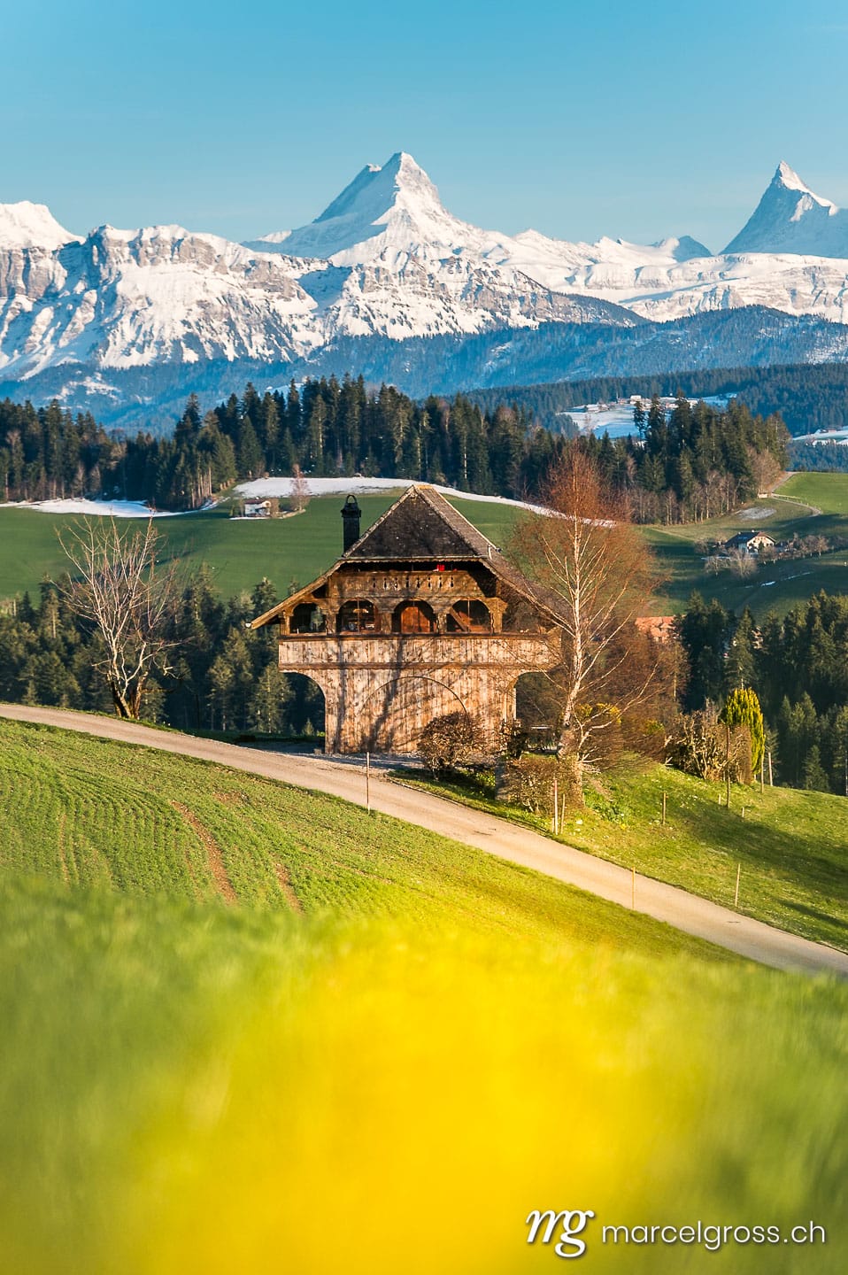 Emmental Bilder. traditional Bernese farmhouse called Stöckli in front of the mighty Schreckhorn and Finsteraarhorn. Marcel Gross Photography