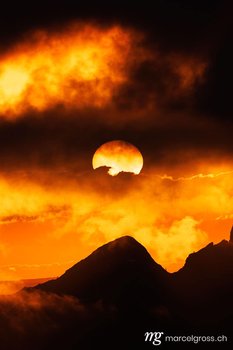 Sommerbilder Schweiz. dramatic sunset with clouds and the sun in the Alpine foothills of Fribourg. Marcel Gross Photography